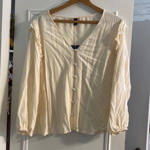 Cream button down blouse with ruffle shoulders
